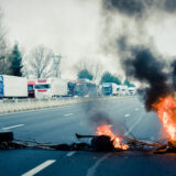 Barricade en feu sur une autoroute bloquant la circulation, illustrant un délit d’entrave routière lors d’une manifestation.