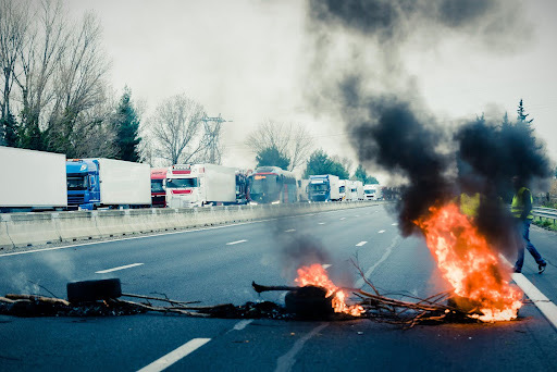 delit-entrave-circulation Barricade en feu sur une autoroute bloquant la circulation, illustrant un délit d’entrave routière lors d’une manifestation.