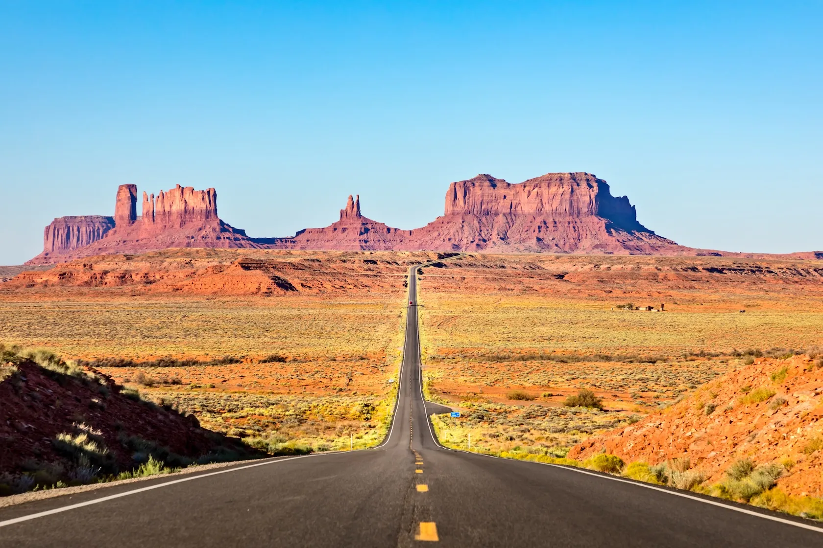 permis-conduire-expatries Route américaine en ligne droite traversant le désert, symbole de liberté et de mobilité pour les expatriés titulaires d’un permis étranger