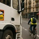 Poids lourd équipé de la signalisation obligatoire des angles morts, en interaction avec un cycliste en milieu urbain — sécurité routière renforcée depuis 2024