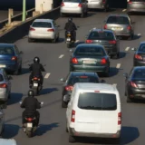 Motocyclistes circulant en inter-files entre les deux voies de gauche sur une autoroute française en trafic dense.