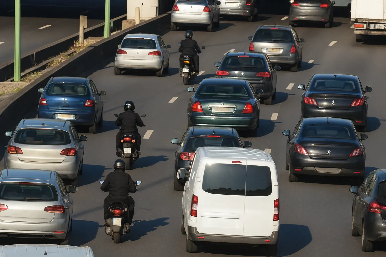 circulation-inter-files Motocyclistes circulant en inter-files entre les deux voies de gauche sur une autoroute française en trafic dense.